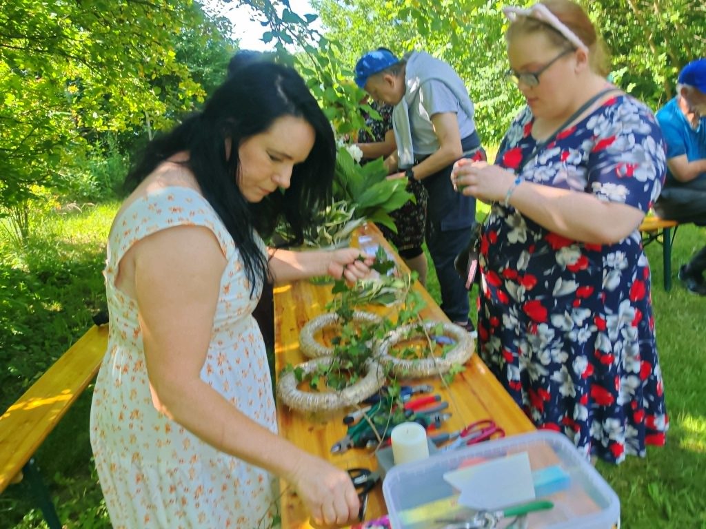 Uczestnicy pikniku wspólnie przygotowują wianki.