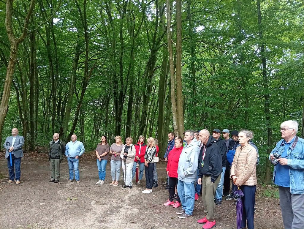 Uczestnicy uroczystości otwarcia nowego ujęcia wody podczas spotkania plenerowego w lesie.