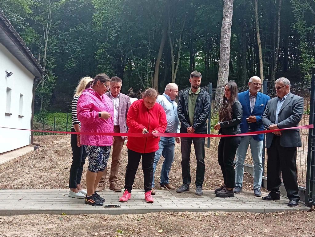 Uroczyste przecięcie wstęgi przez mieszkankę DPS podczas otwarcia nowego ujęcia wody.