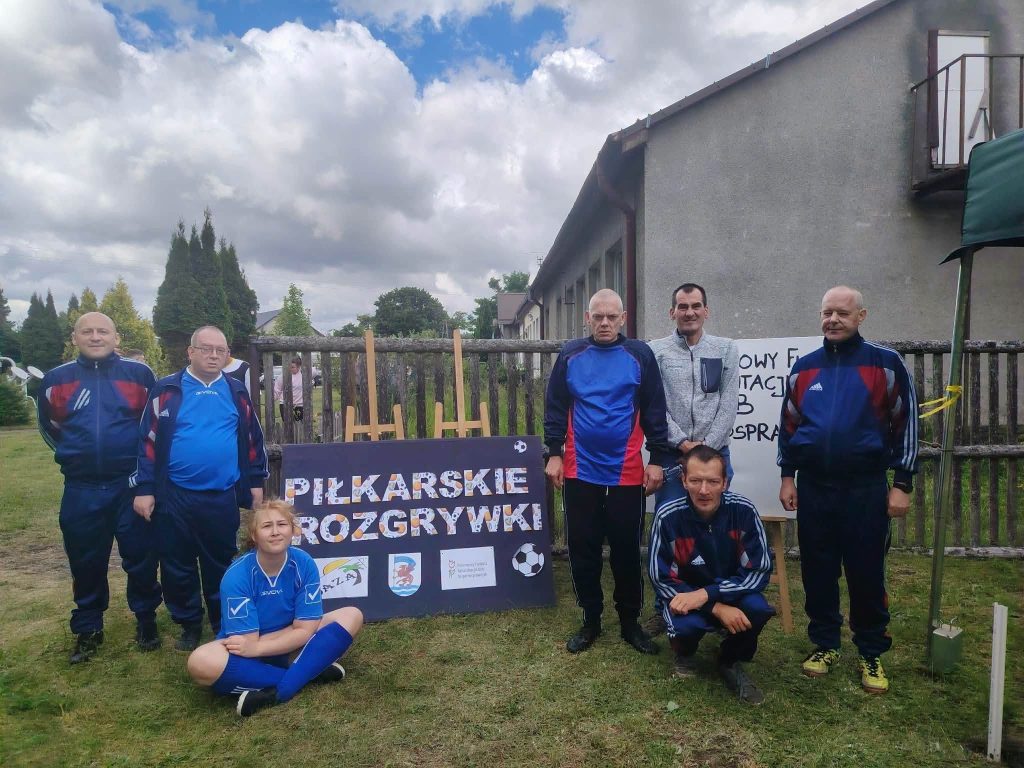 Drużyna DPS w Żydowie pozuje do zdjęcia przy tablicy „Piłkarskie Rozgrywki” podczas turnieju w Krągu.
